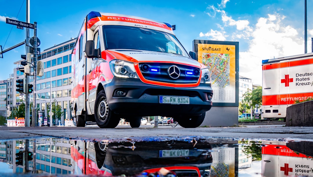 An Ambulance In Action Reflecting In A Puddle!
